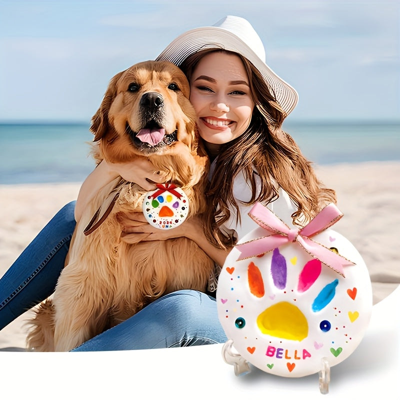 Woman with a dog on the beach holding a colorful paw print disc with 'Bella' on it.