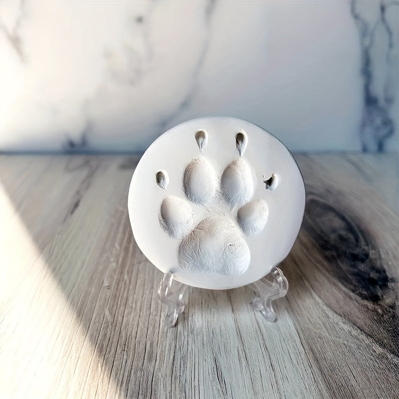 Metallic paw print object on a wooden surface with a blurred background